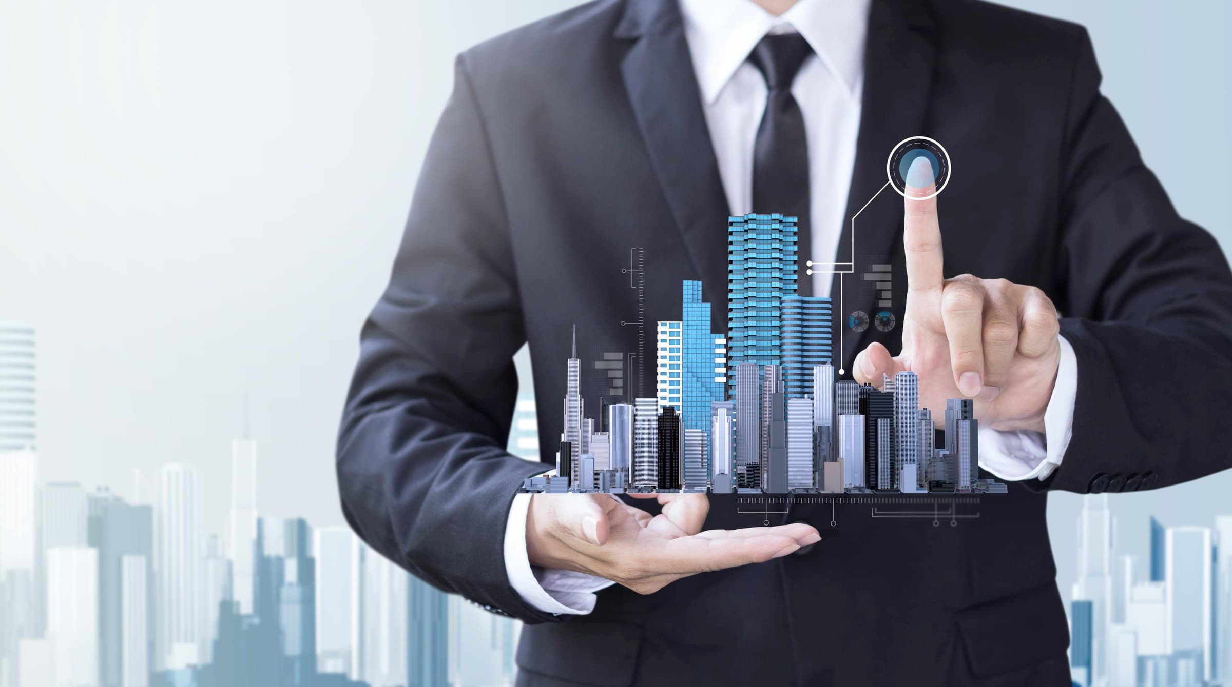 Businessman holding a miniature city skyline with holographic data interface