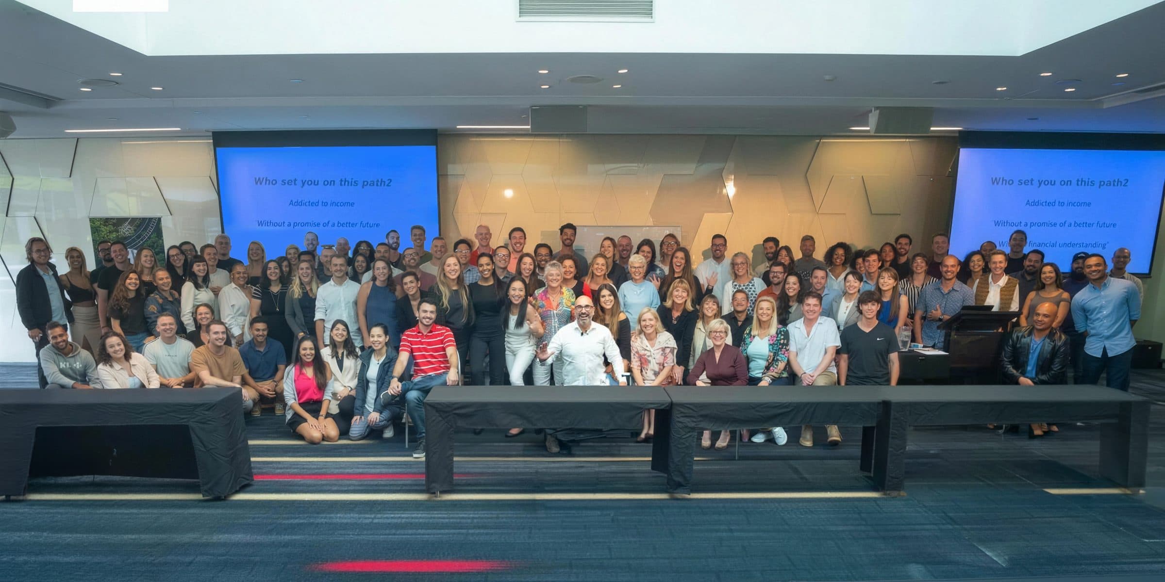 Investors at a JDL Strategies education event, with presentation screens asking “Who set you on this path?”